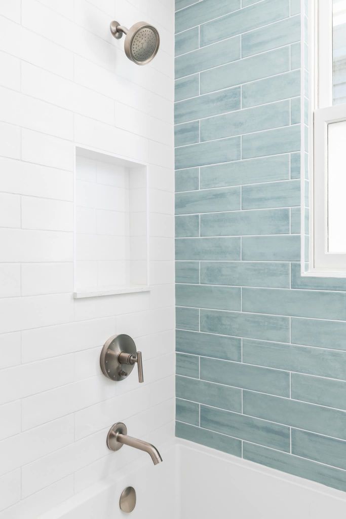 Shower with blue subway tile accent wall