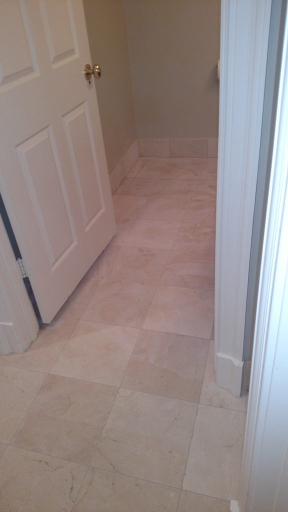 Natural stone tile floor in a hallway leading to a closet
